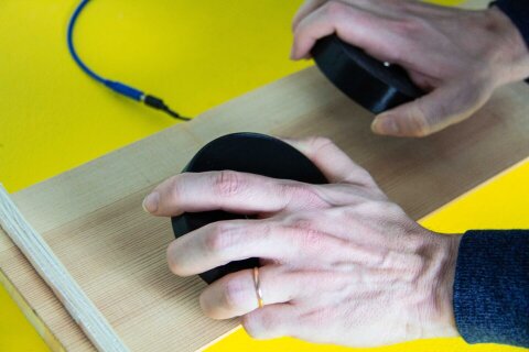 Hands holding black round disks