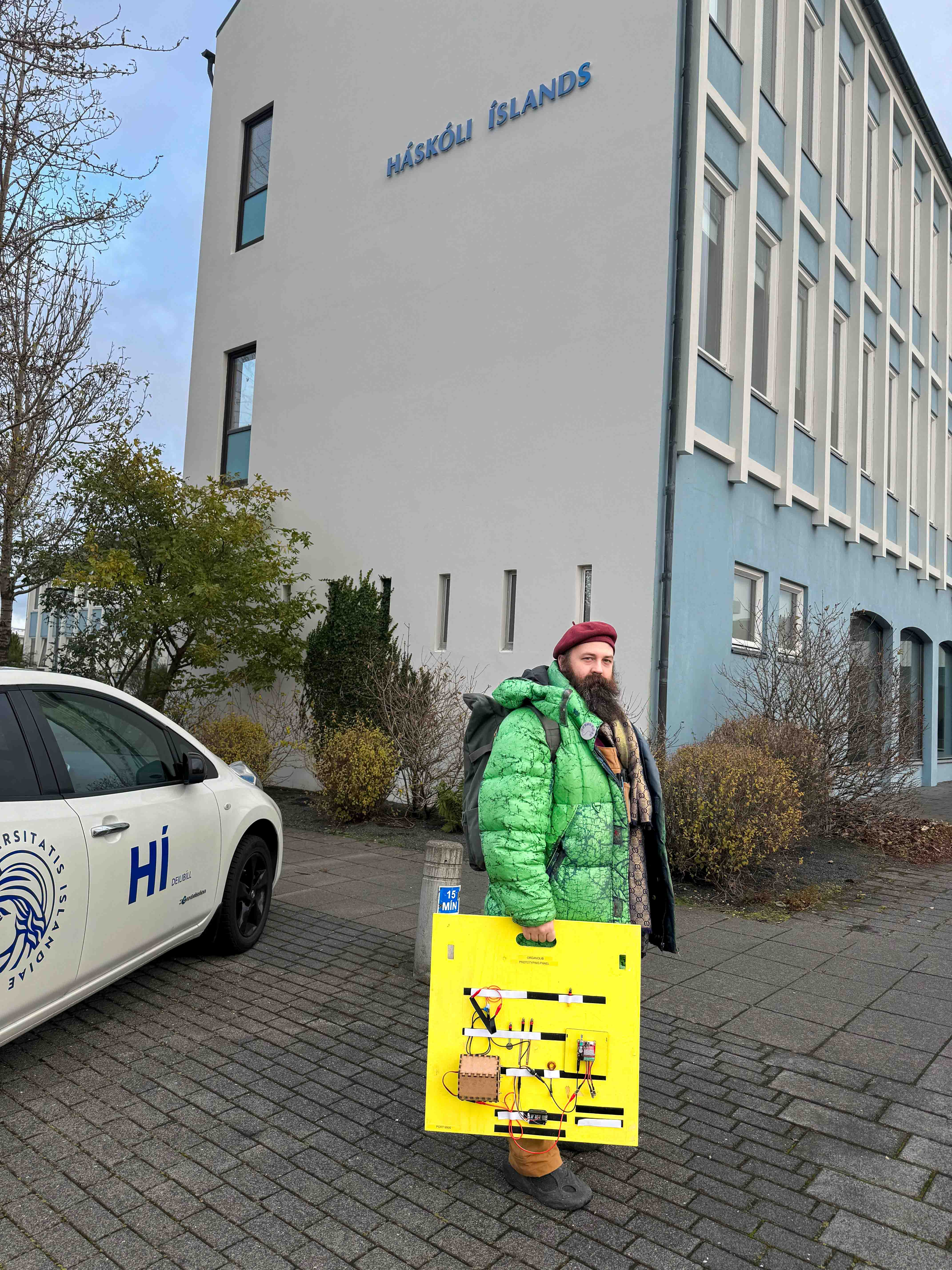 Man standing outside the Uni Iceland with a yellow plank with electric components