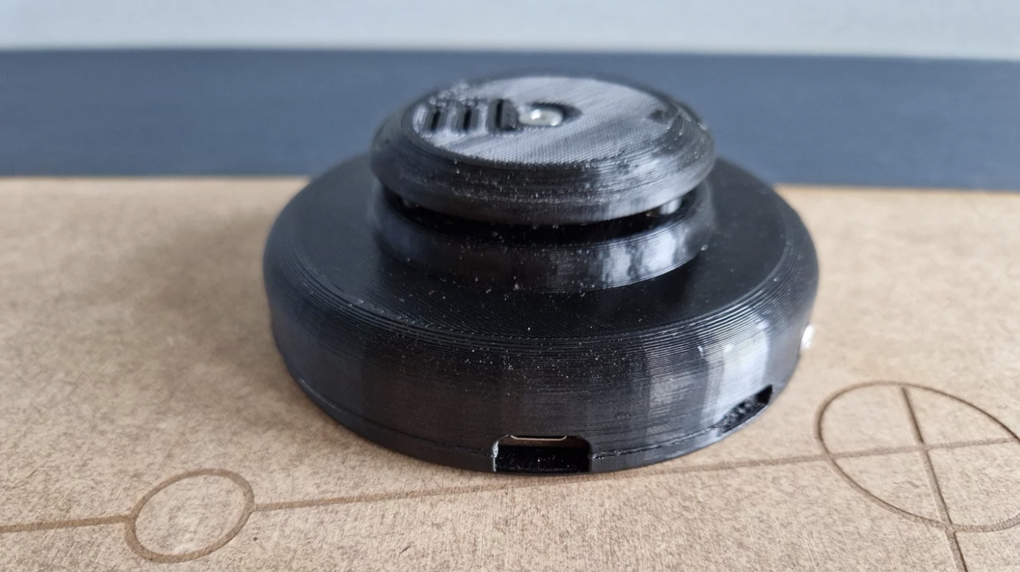 A black puck with a riser on top