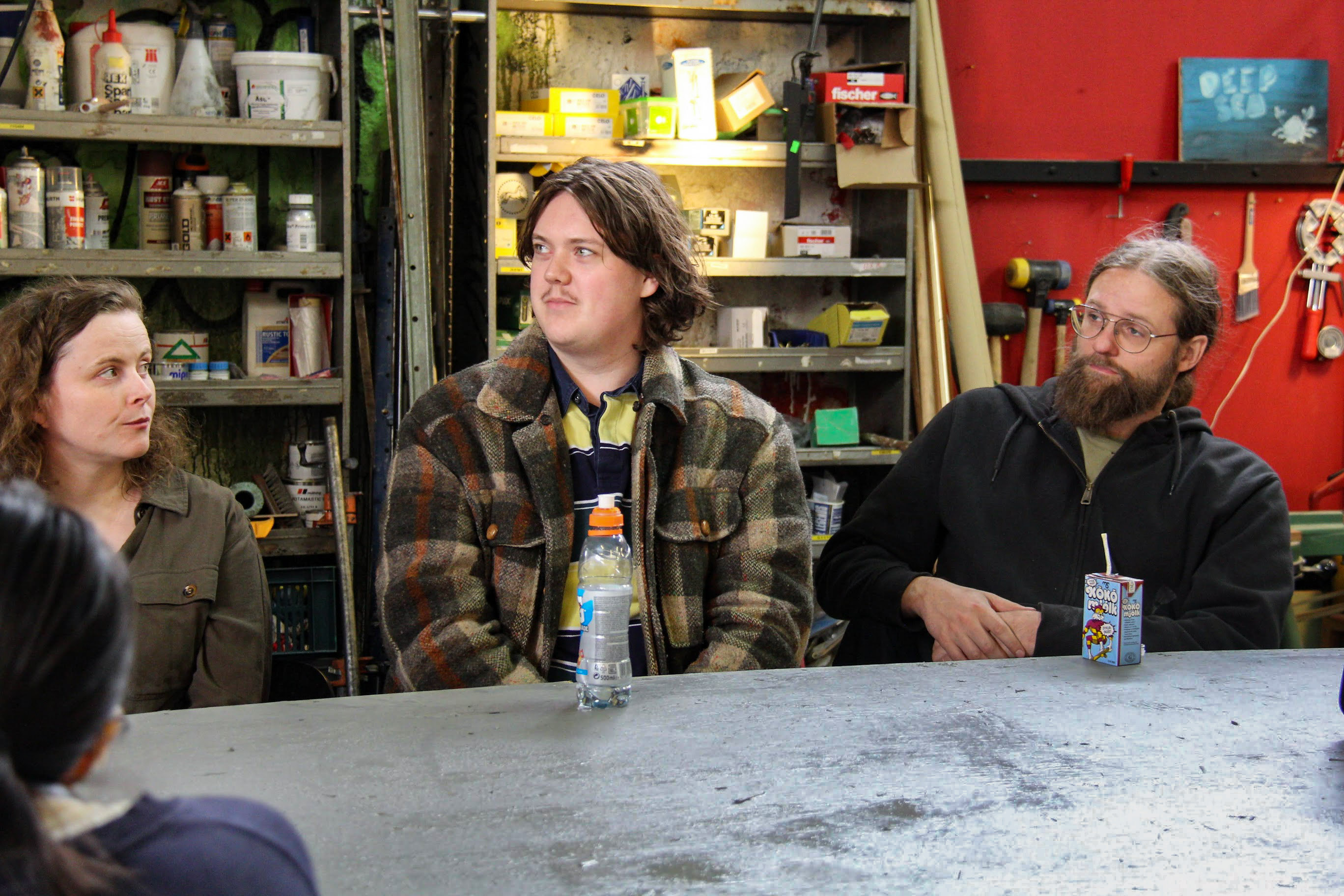 Three people sitting by a table.