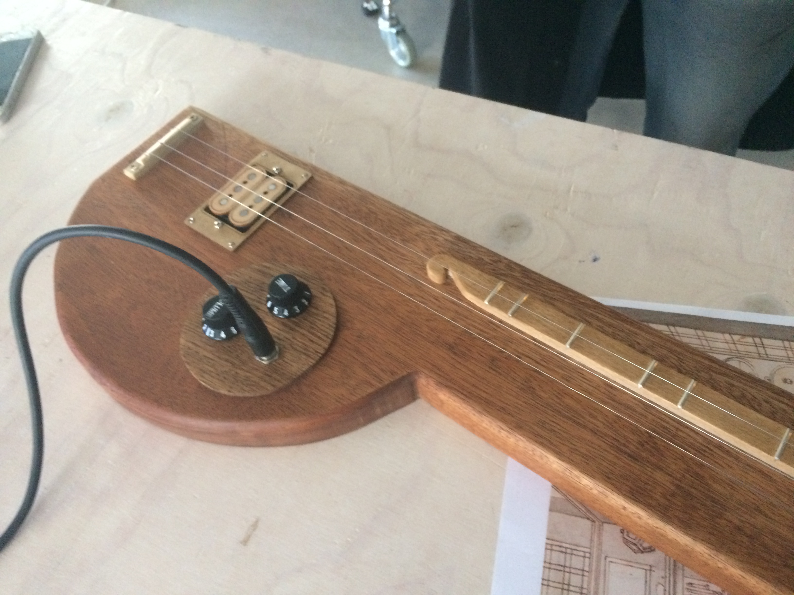 A picture of the langspil. A wooden block with three strings, a jack and two knobs.