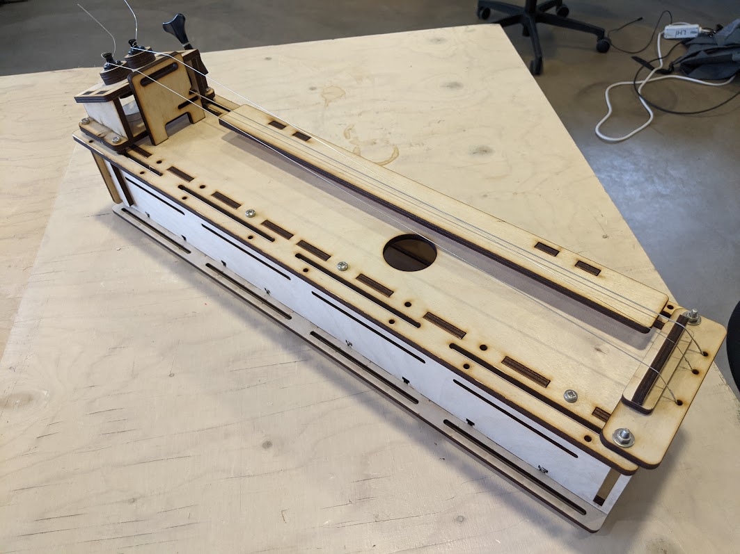A plywood prototype of a long box-shaped instrument.